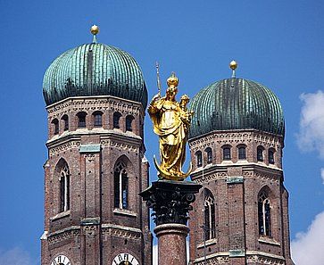 La statua dorata di Santa Maria sulla sua colonna nella Marienplatz e le due torri di della Cattedrale di Monaco (Frauenkirche).