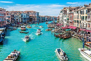 Vista di Canal Grande a Venezia, in una giornata di piena estate, con molte barche.