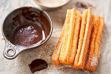 Churros con zucchero e salsa al cioccolato.