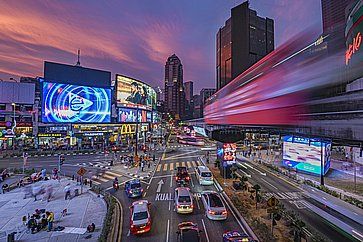 Vista notturna del trafficato quartiere di Bukit Bintang, con la sua stazione ferroviaria monorotaia circondata da grattacieli.