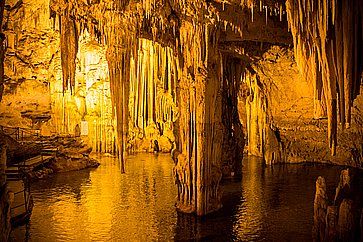 Stalattiti in una luce gialla all'interno della grotta di Nettuno, in Sardegna.