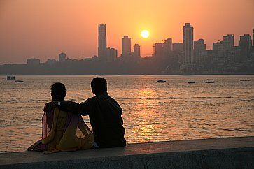 Una coppia ammira il tramonto a Chowpatty Beach (Mumbai).