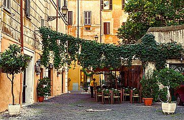 Vecchia via a Trastevere a Roma, con un piccolo ristorante.