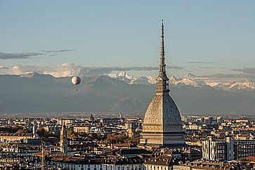 La vista di Torino al tramonto, in primo piano la Mole Antonelliana e sullo sfondo le cime innevate delle Alpi.