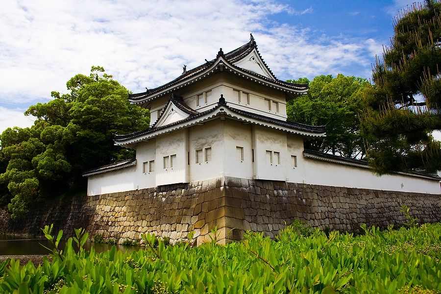 Castello di Nijo a Kyoto con mura bianche e vegetazione rigogliosa.