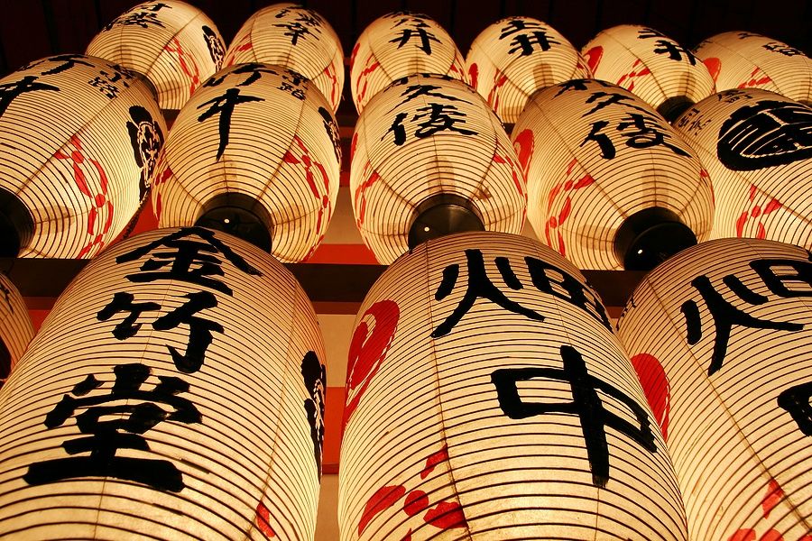 Lanterne giapponesi con caratteri Kanji illuminate di notte.