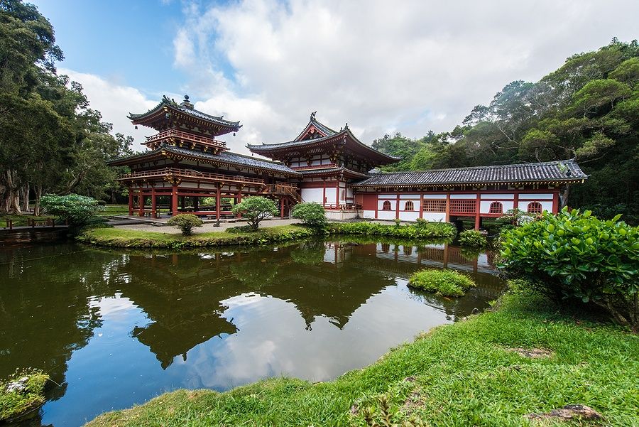 Byodo-In Temple a Oahu con riflesso nello stagno e montagne sullo sfondo.