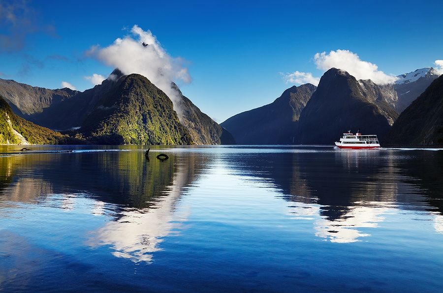 Panorama di Milford Sound con una nave da crociera su acque calme.