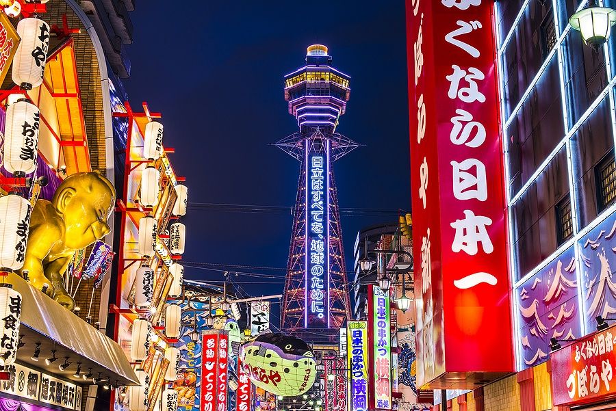 Scena notturna nel quartiere Shinsekai di Osaka con la torre Tsutenkaku.