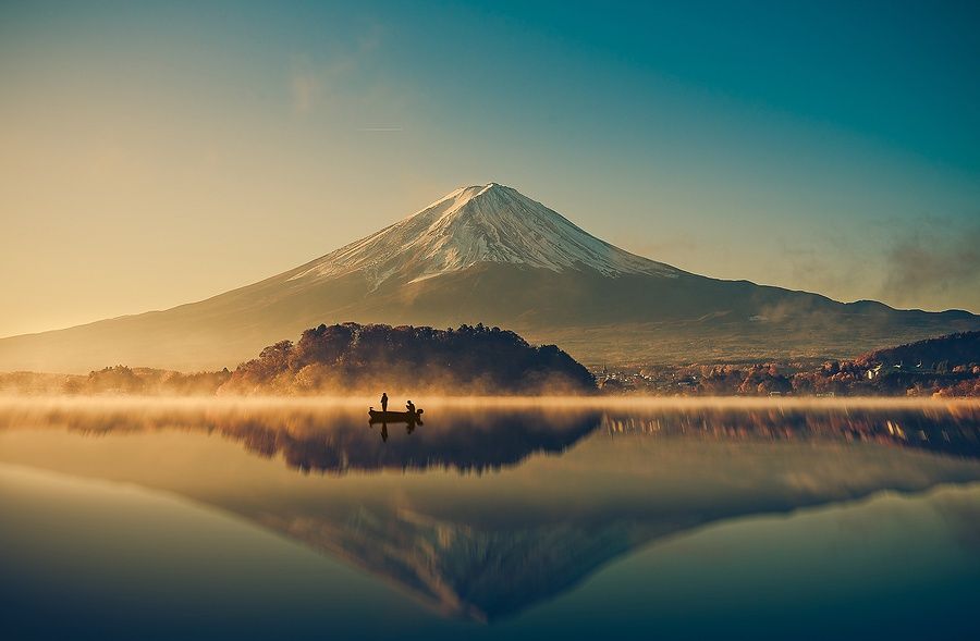 Monte Fuji riflesso nel Lago Kawaguchiko all'alba con una barca.