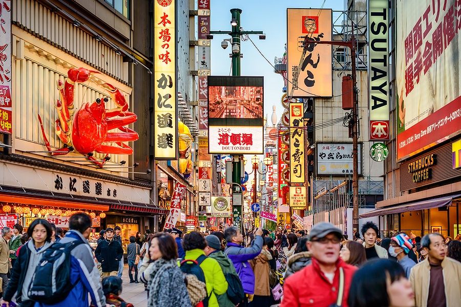 Folla sotto le insegne luminose di Dotonbori a Osaka, Giappone.
