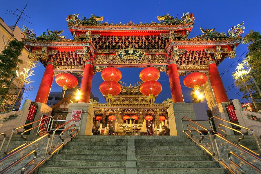 Kwan Tai Temple a Yokohama, Giappone, visto di sera con lanterne illuminate e portale ornato.