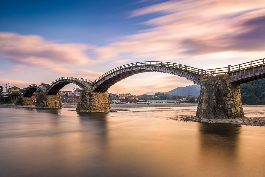 Il ponte Kintaikyo a Iwakuni, Hiroshima, sospeso sopra un fiume al tramonto.