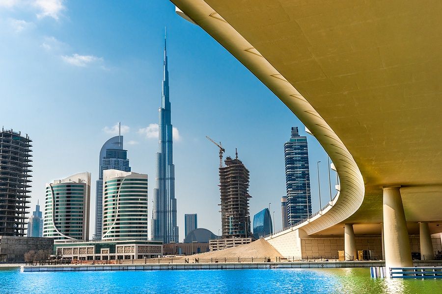 Skyline di Dubai con Burj Khalifa e un ponte, cielo limpido.