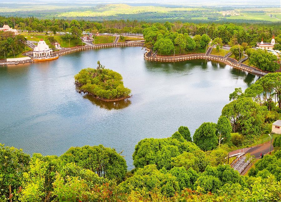 Vista aerea del lago Ganga Talao a Mauritius, circondato da templi e vegetazione.