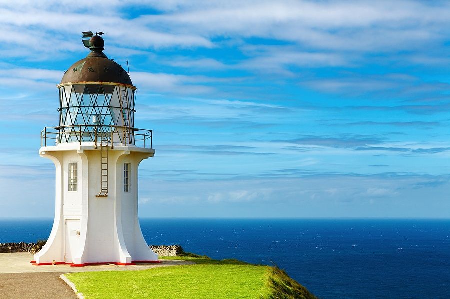 Faro di Cape Reinga con cielo e oceano sullo sfondo.