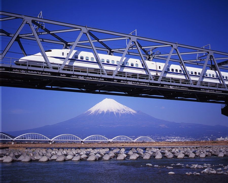Treno Shinkansen su un ponte con il Monte Fuji sullo sfondo.