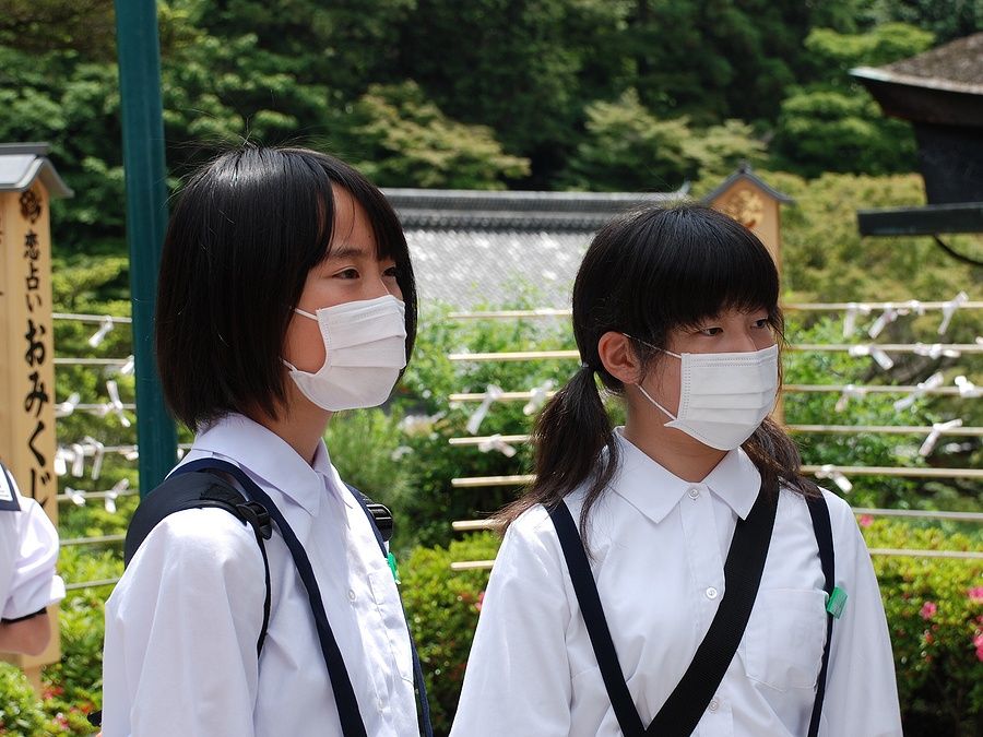 Due studentesse giapponesi con mascherine in visita a un tempio a Kyoto.