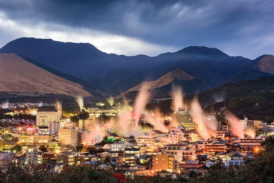 Paesaggio notturno di Beppu con vapore dalle sorgenti termali.