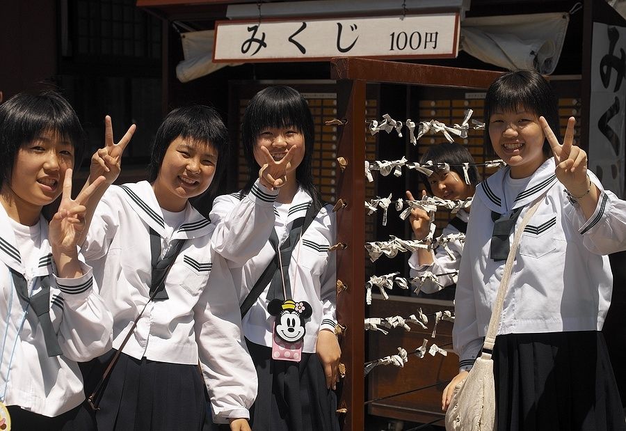 Studentesse giapponesi in posa davanti a un omikuji ad Asakusa, Tokyo.