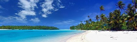 Splendida laguna tropicale con sabbia bianca e palme sotto un cielo azzurro.