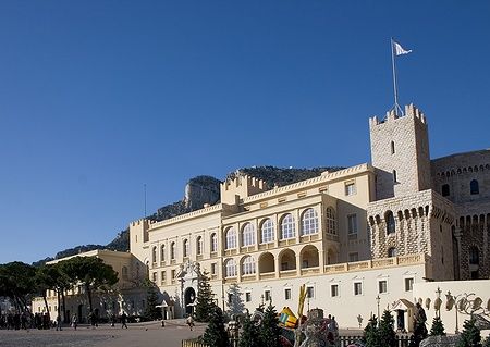Il Palazzo del Principe a Montecarlo, Monaco, con cielo limpido e persone in piazza.