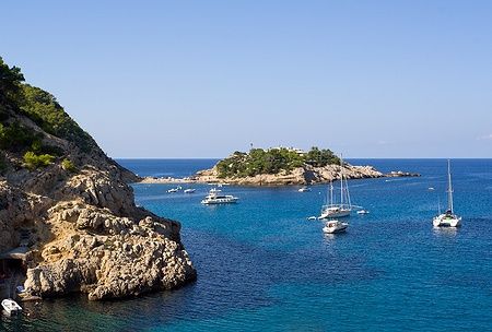 Barche a vela nella baia di Port de Sant Miguel, Ibiza, con scogliere.