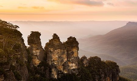 Il sole sorge illuminando le Tre Sorelle nei Monti Blu, Australia.
