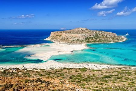 Spiaggia di Balos a Creta con acque cristalline e sabbia bianca sotto un cielo azzurro.