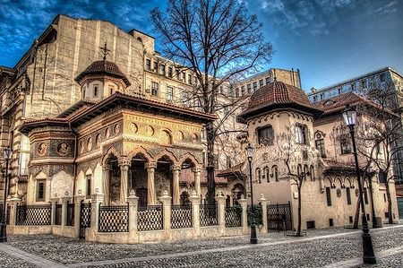 Chiesa Stavropoleos nel centro storico di Bucarest in un ambiente urbano.