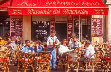 Caffè all'aperto nel Cours Saleya a Nizza, con clienti seduti.