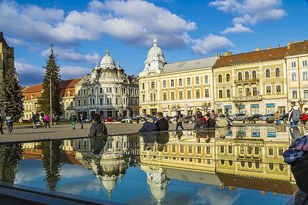 Centro di Cluj-Napoca con edifici storici e persone che passeggiano.