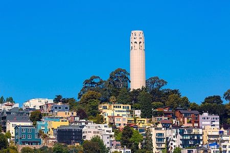 La Coit Tower a San Francisco con cielo azzurro e case colorate.
