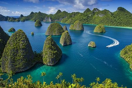 Vista delle isole Wayag a Raja Ampat, con pinnacoli di roccia e acque blu cristalline.