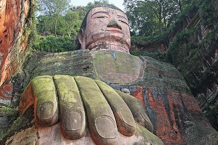 Leshan Giant Buddha tra le rocce e la vegetazione.