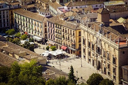 Vista della Plaza Nueva a Granada, Spagna, con edifici storici e persone.