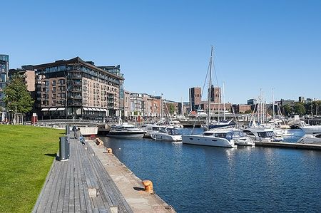 Vista di Aker Brygge, Oslo, con yacht ormeggiati e moderni edifici lungo il fiordo.