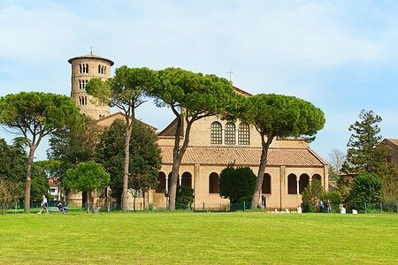 Basilica di Sant'Apollinare in Classe con persone e vegetazione intorno.
