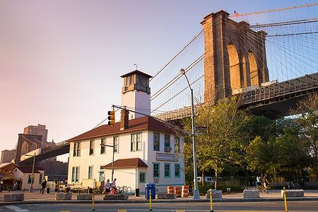 Brooklyn Bridge e edificio storico a DUMBO, New York, in una serata estiva.