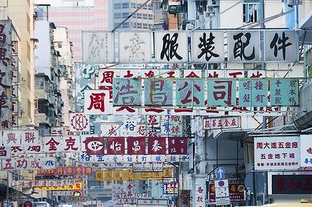 Cartelloni pubblicitari su una strada affollata a Hong Kong con scritte in cinese.