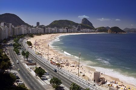 Copacabana Beach a Rio de Janeiro con Pão de Açúcar sullo sfondo e molte persone sulla spiaggia.