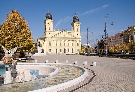 Piazza principale di Debrecen con chiesa gialla e fontana.