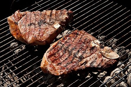 Due bistecche fiorentine di Chianina su griglia a carbone.