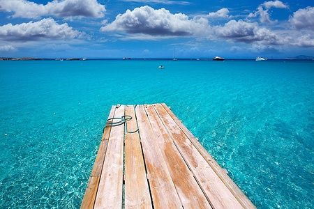 Passerella sulla spiaggia di Ses Illetes a Formentera con mare cristallino.
