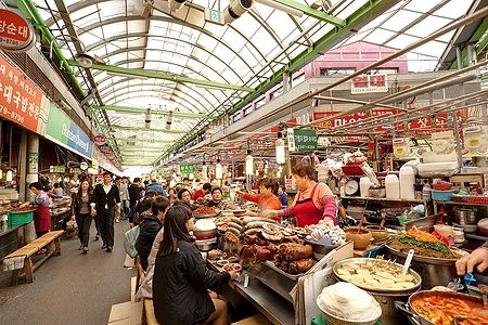 Venditrici cucinano cibo tradizionale al Gwangjang Market, Seoul.