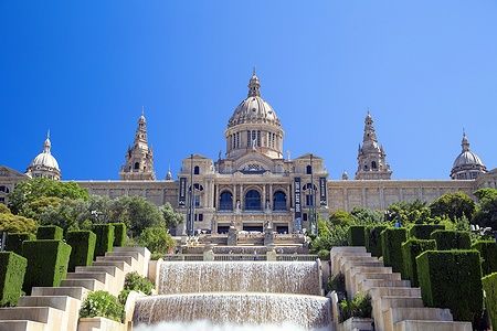 Facciata del MNAC a Barcellona con giardini e fontane.