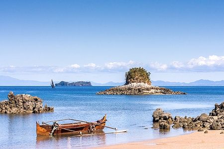 Scena costiera vicino all'isola di Nosy Be, Madagascar, con barca e isolotto.
