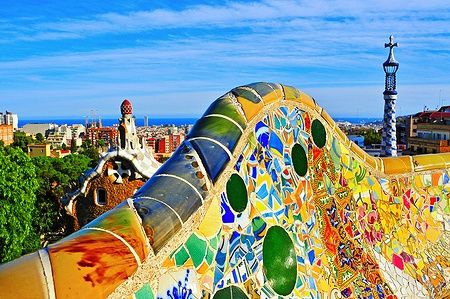 Panchina a mosaico colorato nel Park Güell di Barcellona con vista sulla città.
