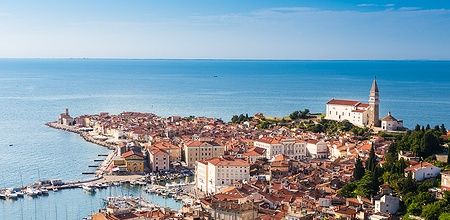 Panoramica di Piran sulla costa adriatica slovena con tetti rossi e mare blu.