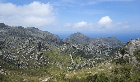 Serra de Tramuntana a Maiorca, Spagna, con paesaggio montuoso e cielo azzurro.